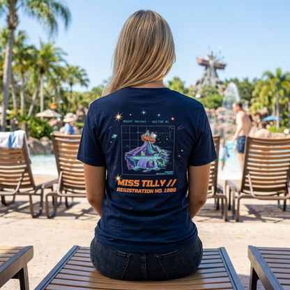 Person wearing a navy blue t-shirt with a colorful graphic design outdoors.