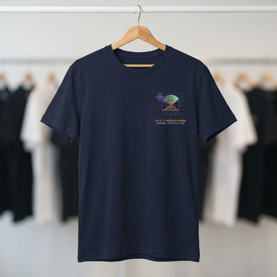 Navy blue t-shirt with a graphic design on a hanger against a blurred clothing rack background.