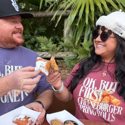 Two people enjoying food outdoors, wearing matching t-shirts with a cheeseburger graphic.