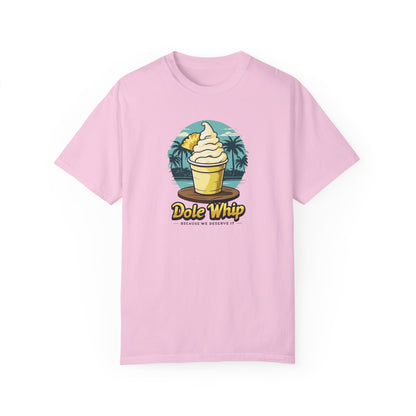 A pink disney t-shirt with a graphic of a Dole Whip ice cream, surrounded by a tropical landscape with palm trees.