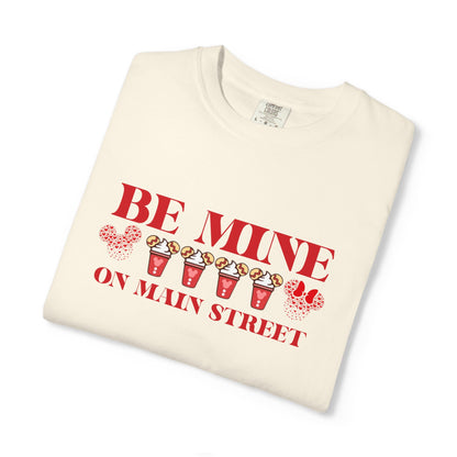 Folded cream-colored t-shirt with red text and graphics on a white background
