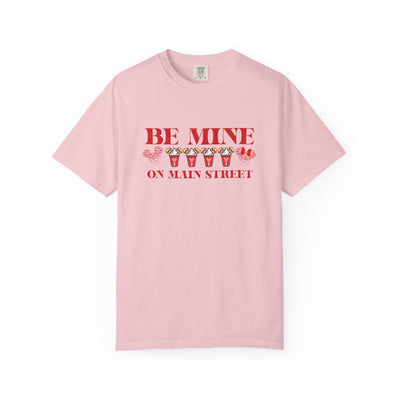 Pink t-shirt with 'Be Mine on Main Street' text and graphics on a white background