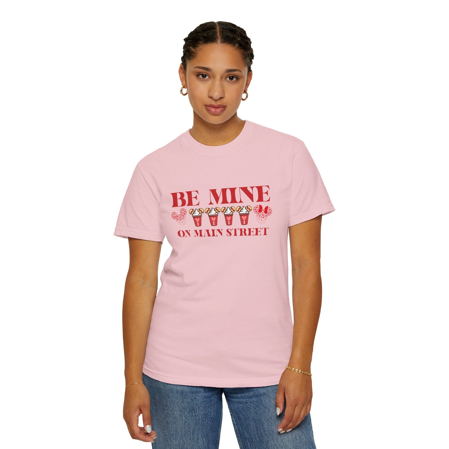 Person wearing a pink t-shirt with 'Be Mine on Main Street' text and candy corn graphics.