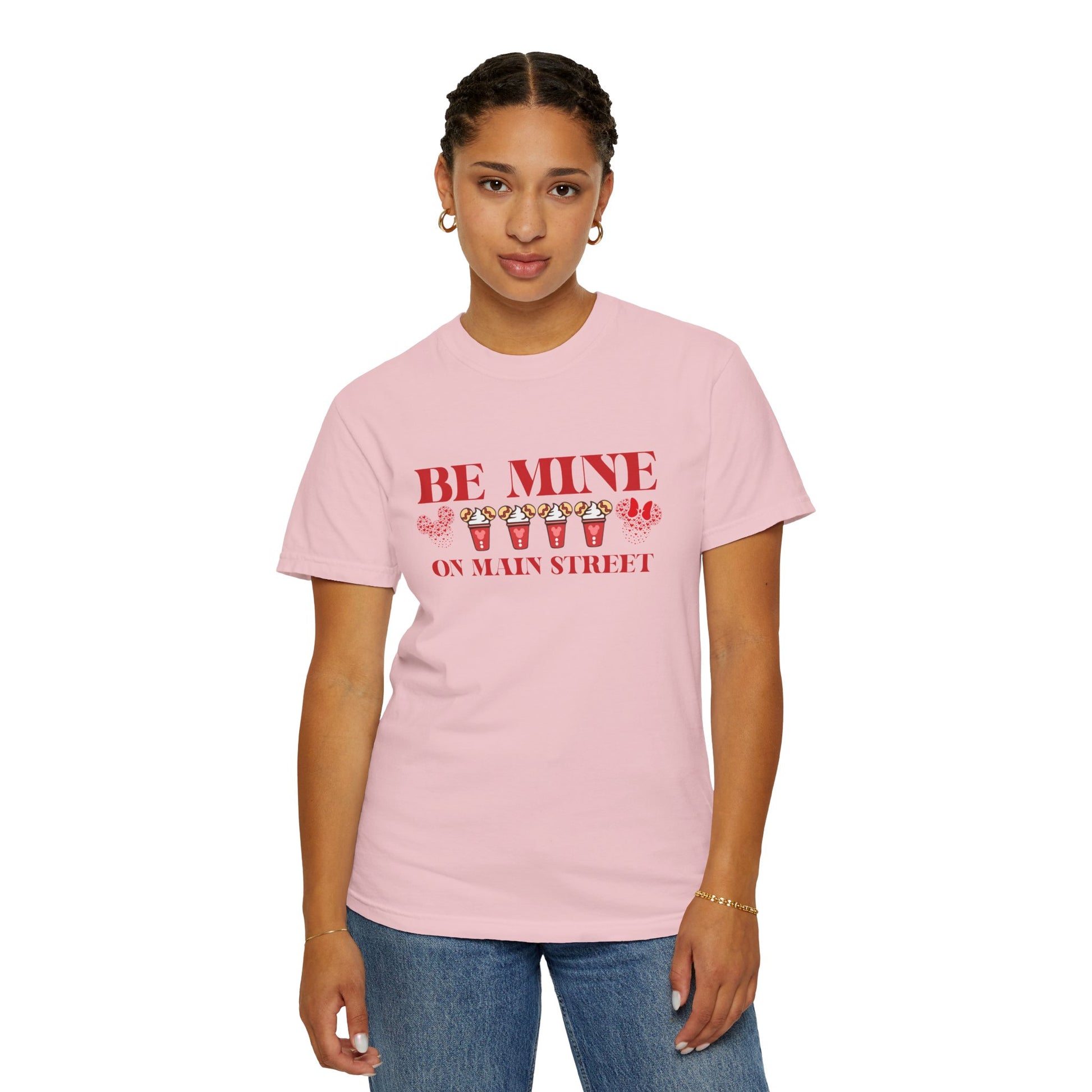 Person wearing a pink t-shirt with 'Be Mine on Main Street' text and candy corn graphics.