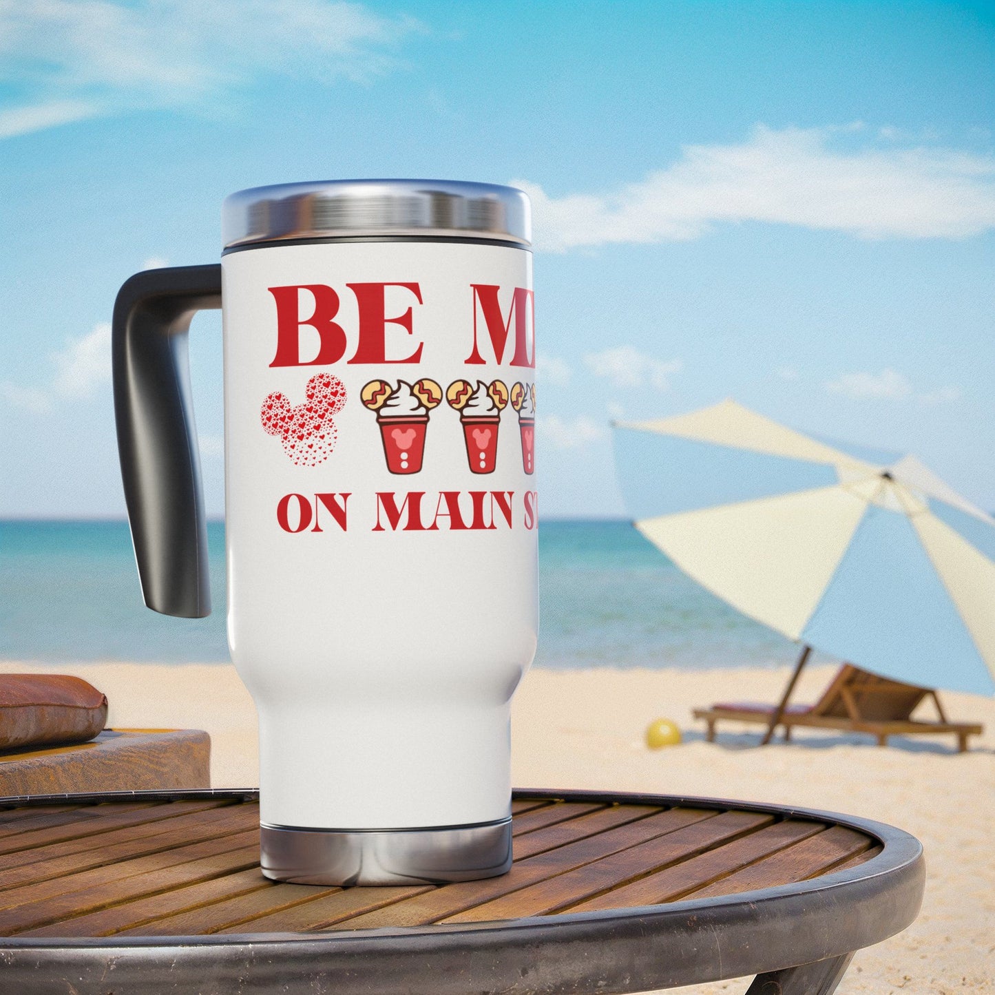 White travel mug with red text and graphics on a beach setting