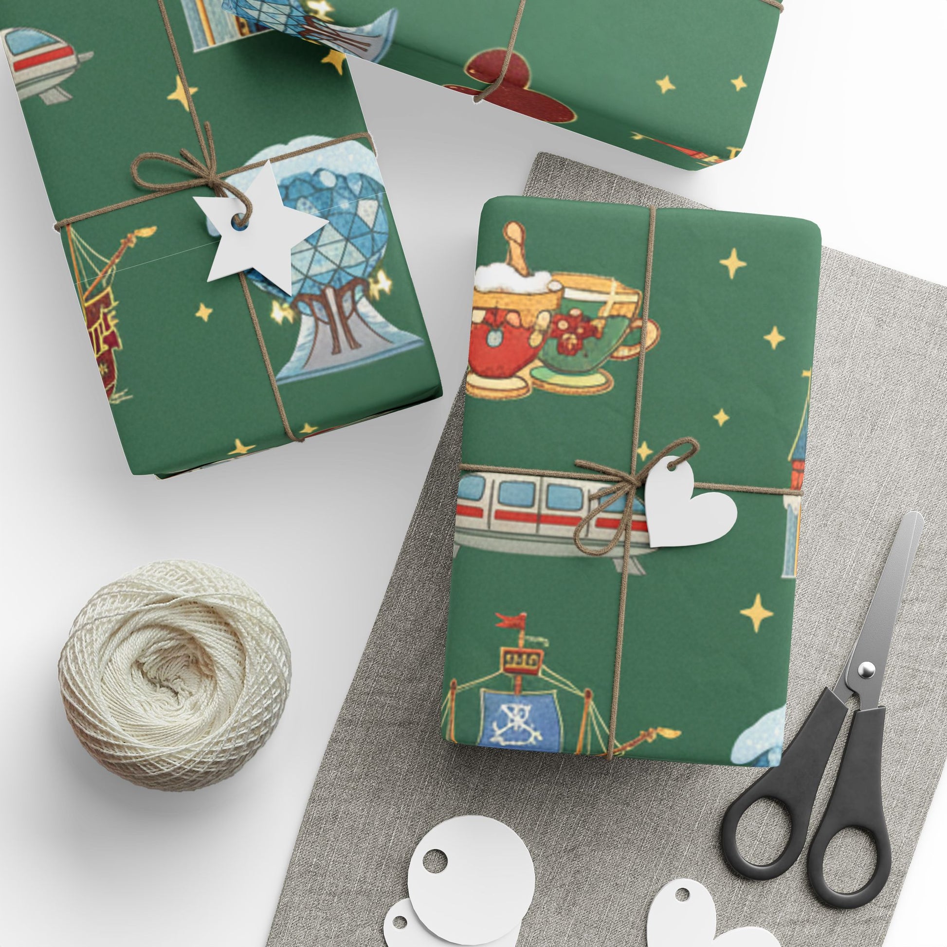 Green gift wrap with festive designs, scissors, and yarn on a white surface