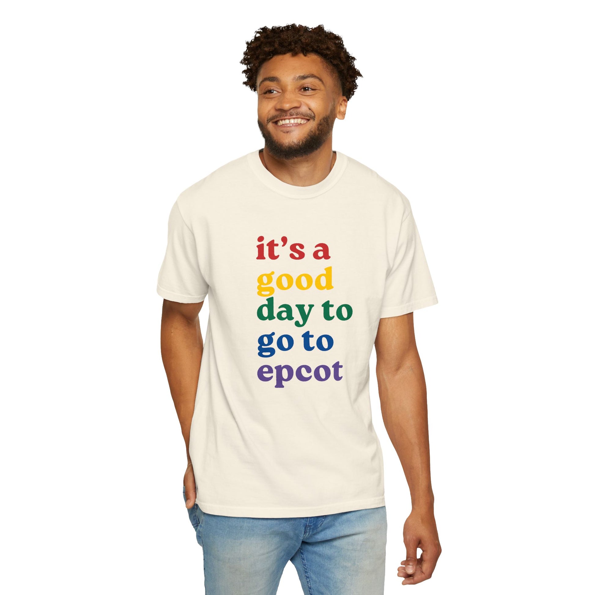 Man wearing a cream t-shirt with colorful text 'it's a good day to go to epcot' on a white background