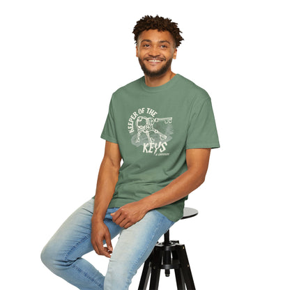 Man wearing a green t-shirt with a graphic design sitting on a stool against a white background