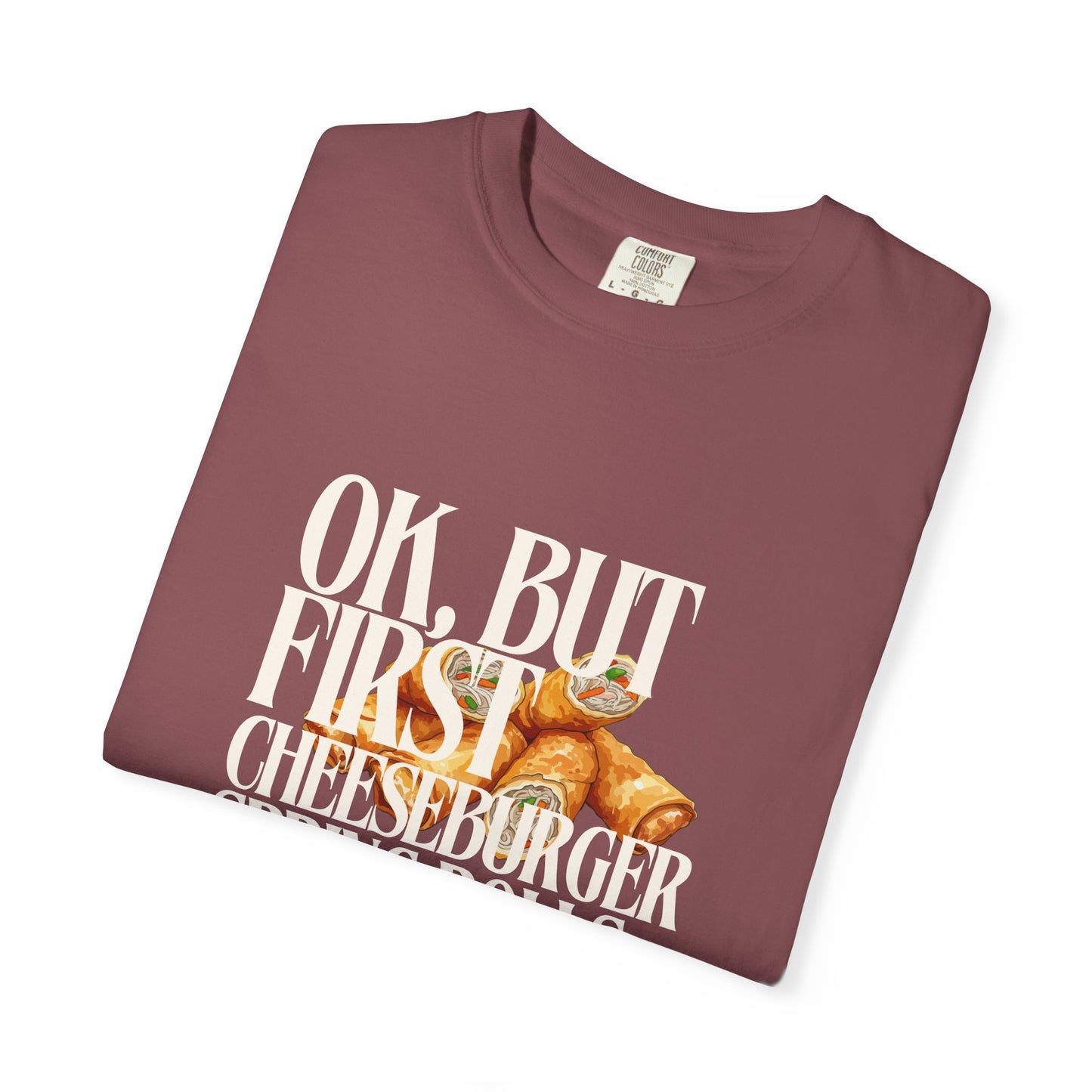 Folded maroon t-shirt with cheeseburger graphic and text on a white background