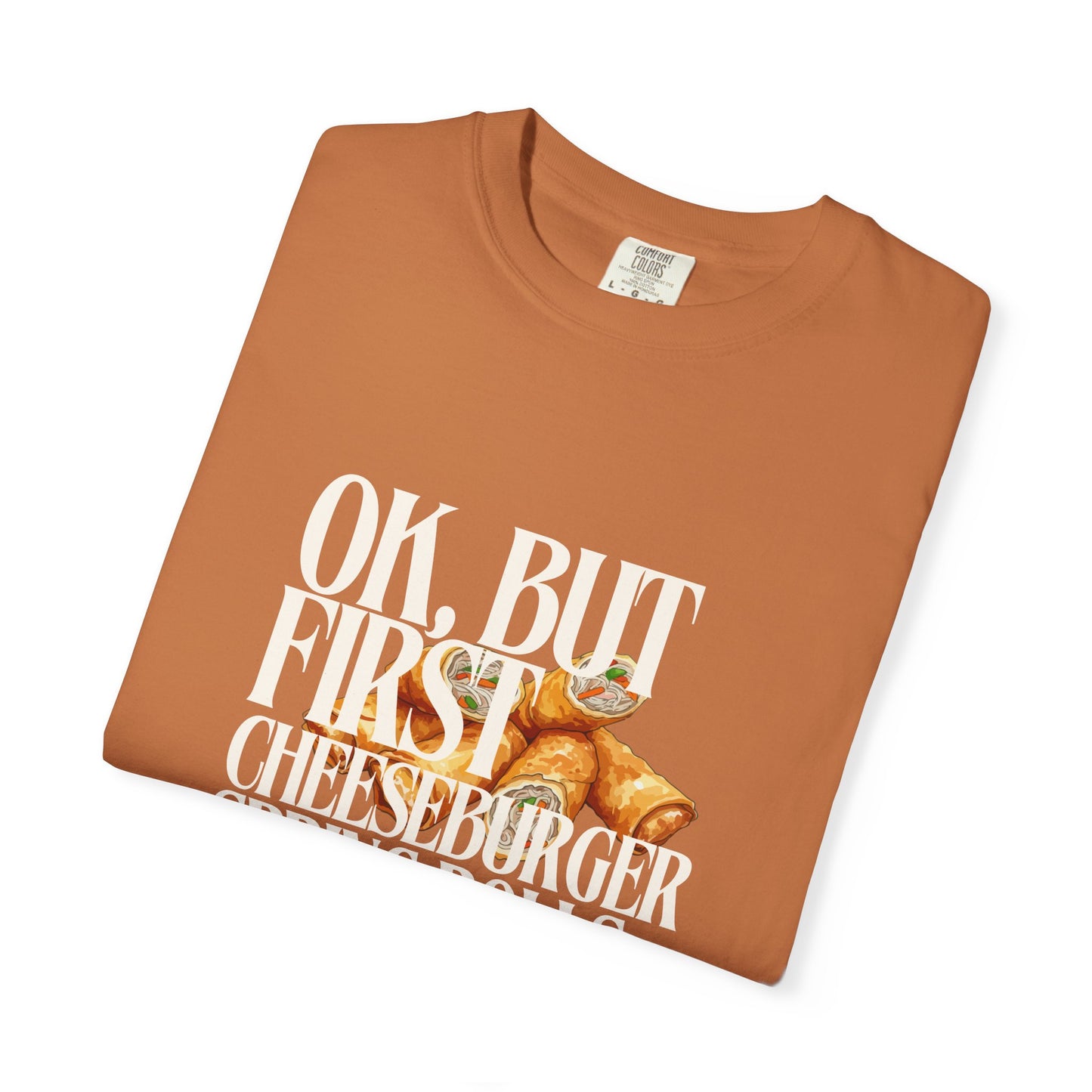 Folded brown t-shirt with cheeseburger graphic and text on a white background