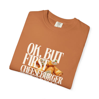 Folded brown t-shirt with cheeseburger graphic and text on a white background